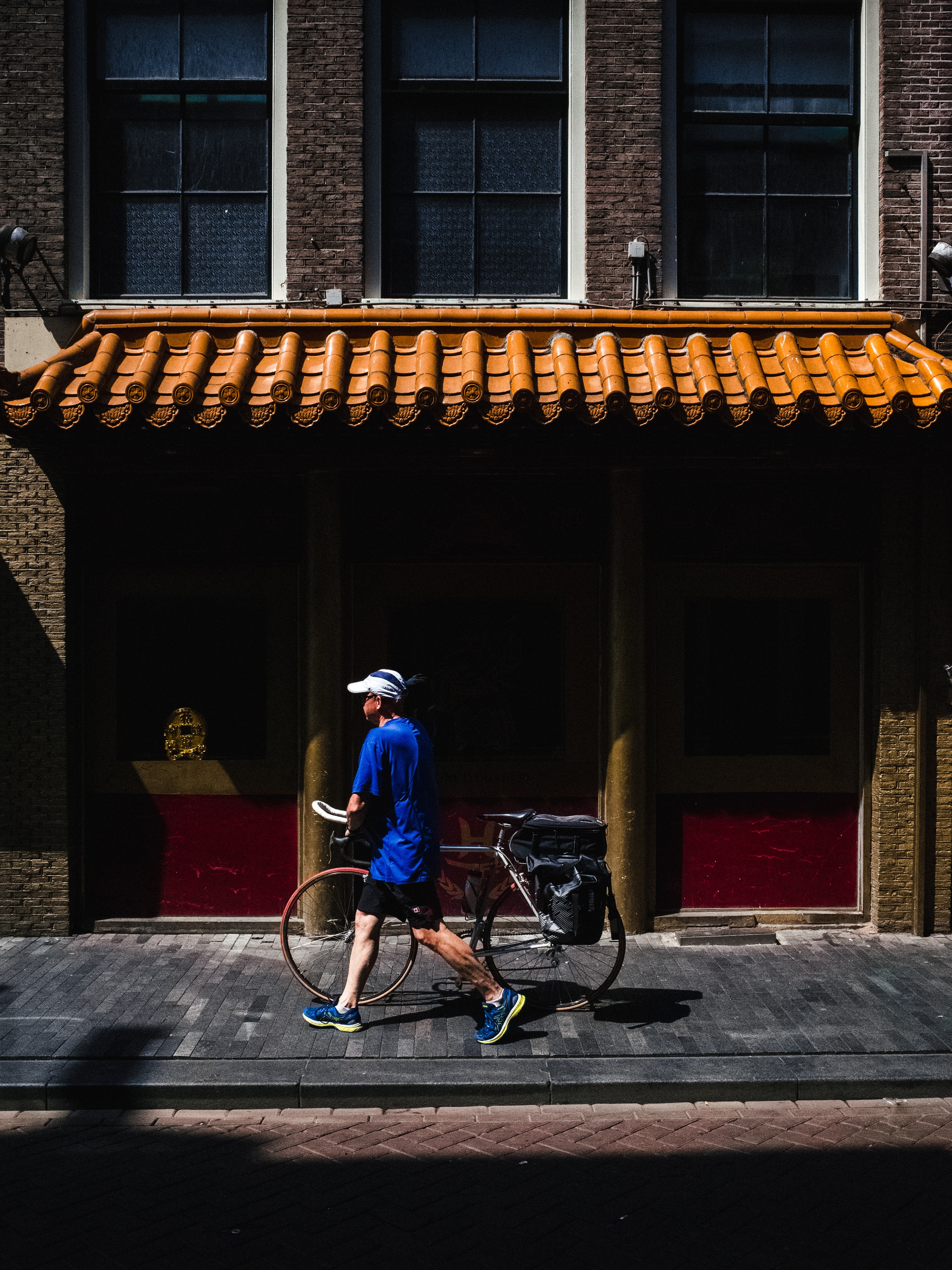 Man loopt met zijn fiets in de straten van de stad