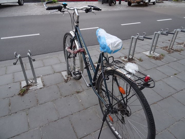 Blauwe fiets in de standaard geparkeerd