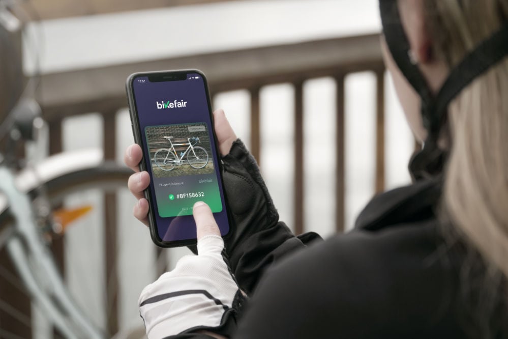 the person looking at the phone at the newly received bike nft