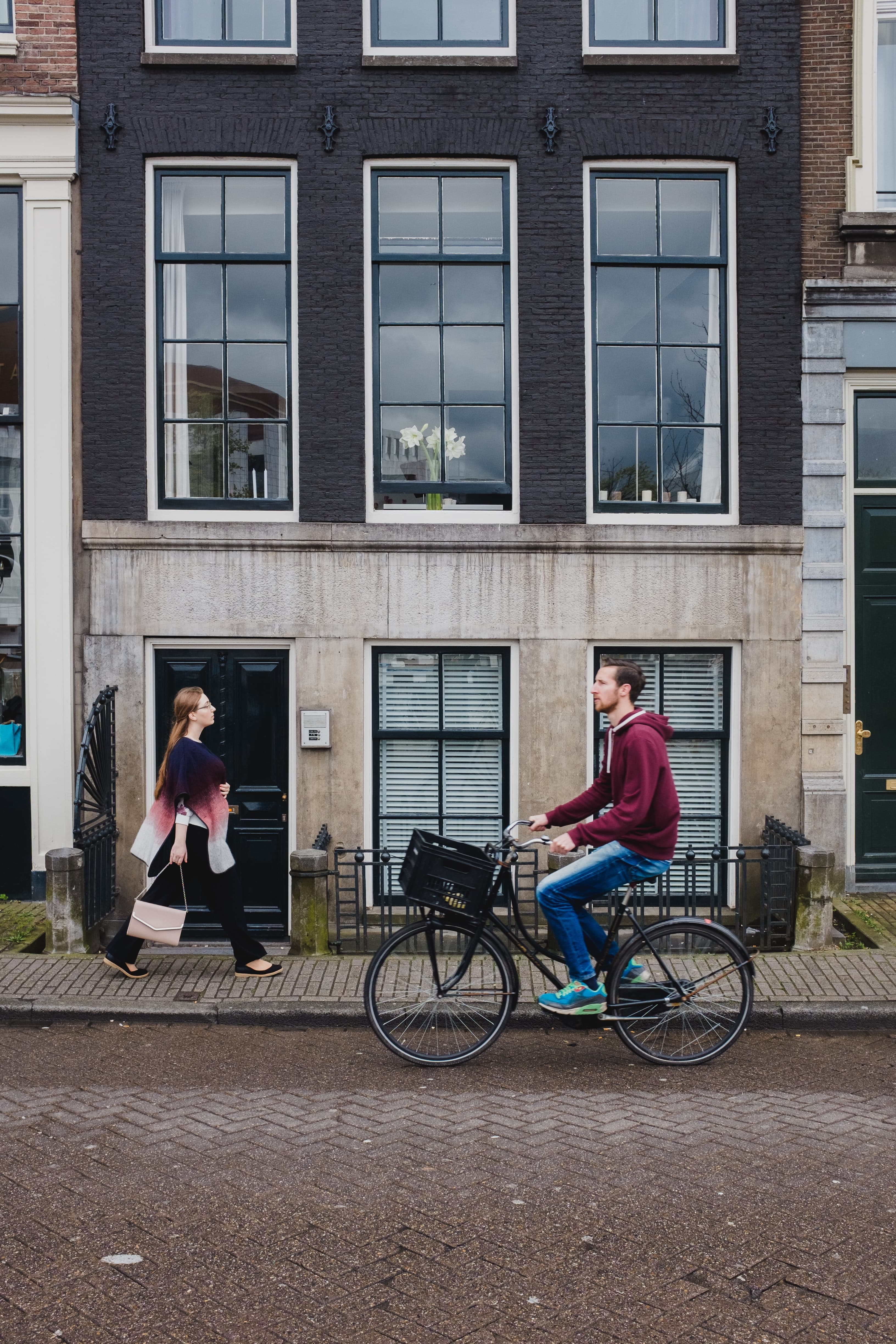 Man riding black city bike with black basket in front