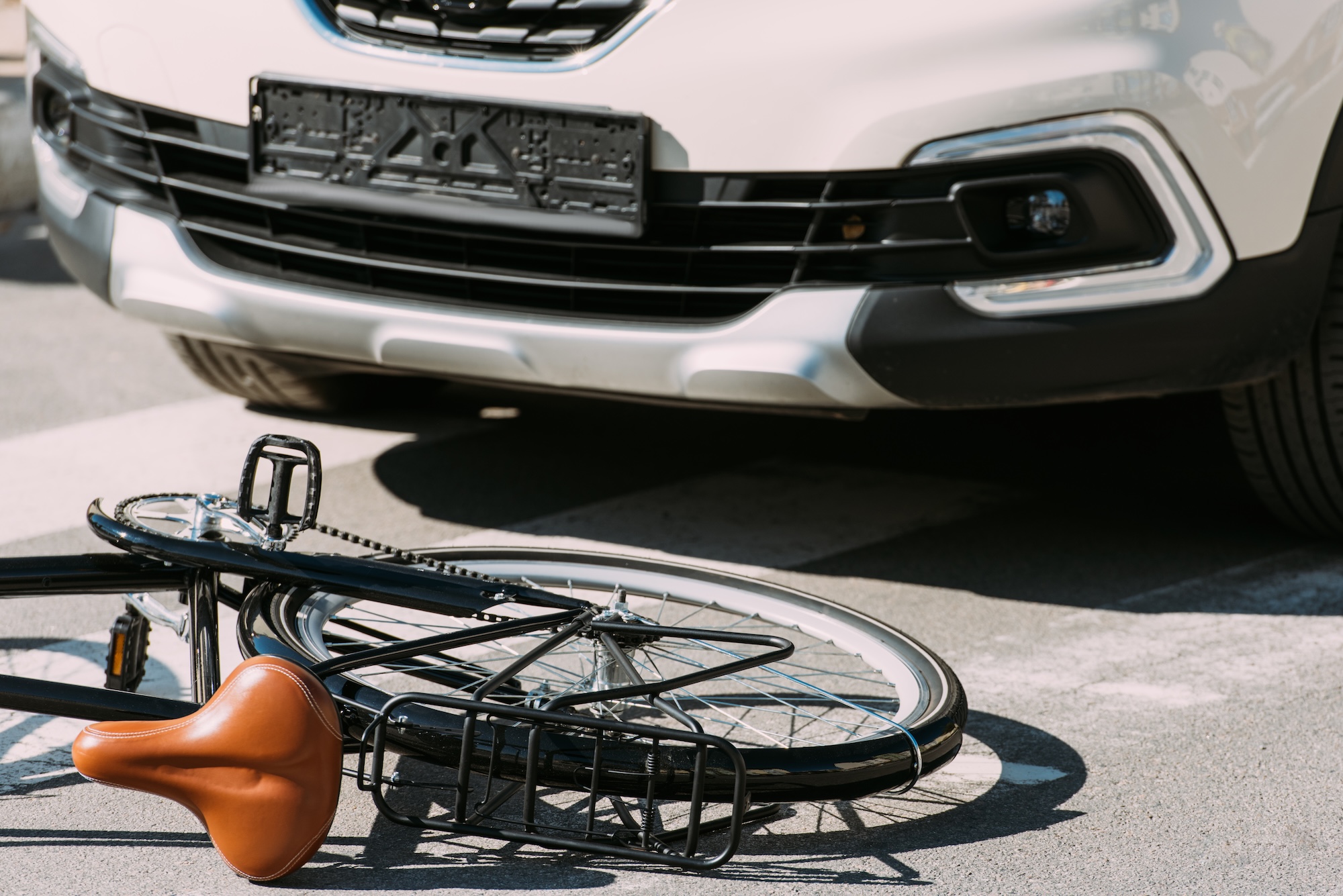 Beschadigde fiets tegen een auto na een aanrijding